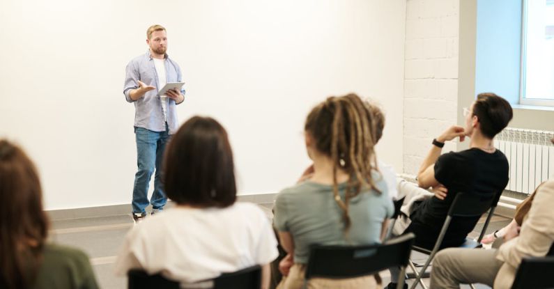 Classes - Man Wearing Gray Dress Shirt and Blue Jeans